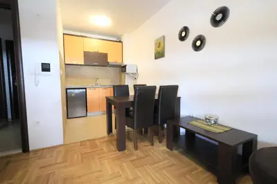 a kitchen and dining room with a table and chairs at Status-M Apartments Rozino in Budva