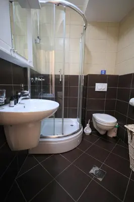 a bathroom with a sink and a shower and a toilet at Status-M Apartments Rozino in Budva