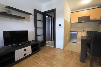 a living room with a television and a kitchen at Status-M Apartments Rozino in Budva