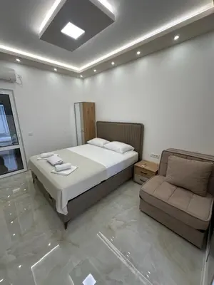 a bedroom with a bed and a couch in it at Apartmani Resetar 2 in Brca