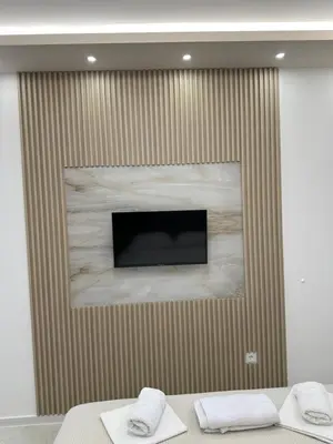 a wall with a television and two towels at Apartmani Resetar 2 in Brca