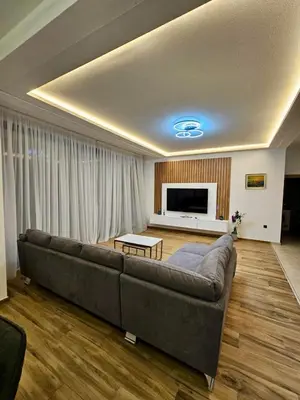 a living room with a couch and a television at Villa LuceSole Budva in Budva