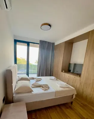 a bedroom with a bed and a large window at Villa LuceSole Budva in Budva