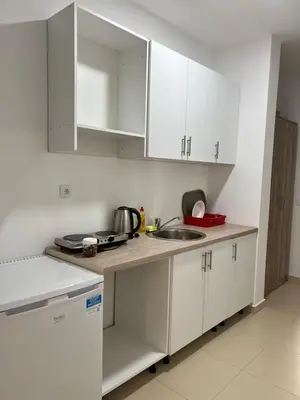 a kitchen with white cabinets and a sink at Apartments Drini in Ulcinj