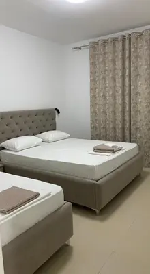 two twin beds in a bedroom with curtains at Apartments Drini in Ulcinj