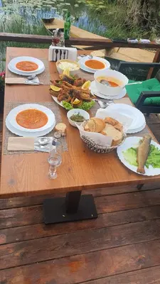a wooden table with plates of food on it at Apartman Skadarsko jezero bay in Vranjina
