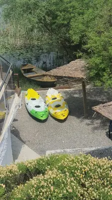 three kayaks sitting on the ground next to a table at Apartman Skadarsko jezero bay in Vranjina