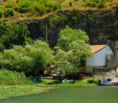 a house on the side of a river at Apartman Skadarsko jezero bay in Vranjina