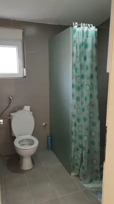 a bathroom with a toilet and a shower curtain at Liona in Sutomore