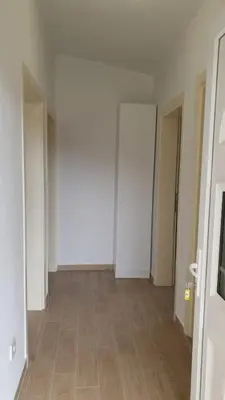 an empty hallway with white walls and wooden floors at Liona in Sutomore