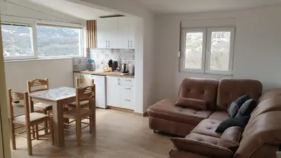 a living room with a couch and a table and a kitchen at Liona in Sutomore