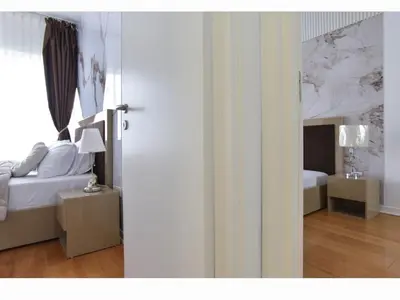 a bedroom with a bed and a table with a lamp at Luxury apartment with 2 rooms in hotel Tre canne in Budva