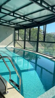 a large swimming pool with blue water and windows at Appartment Do and Pool in Ulcinj