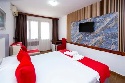 a hotel room with two beds and a flat screen tv at Apartments Palma in Budva