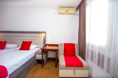 a bedroom with two beds and a desk with a red seat at Apartments Palma in Budva