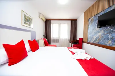 a bedroom with a large white bed with red pillows at Apartments Palma in Budva