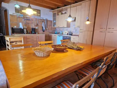 a kitchen with a wooden table with baskets on it at Stonehouse Mimi in Lapčići