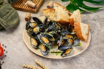 a plate of mussels and slices of bread on a table at Montebar2 in Brca