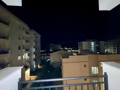 a view of a city at night from a balcony at Deluxe Studio Apartment with Sea View in Bar