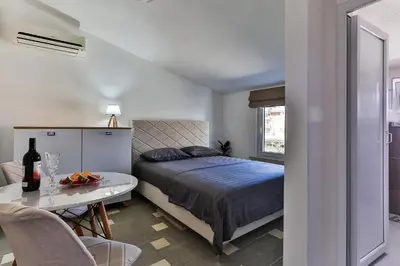 a bedroom with a bed and a table with a bottle of wine at Shanti apartments in Bar
