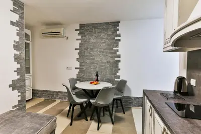 a dining room with a table and chairs in a kitchen at Shanti apartments in Bar