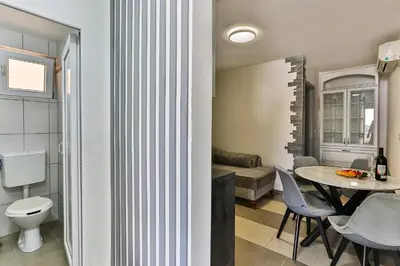 a living room with a toilet and a table at Shanti apartments in Bar
