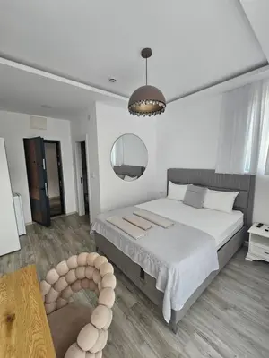 a bedroom with a large bed and a table at La Vida Apartments in Babalonija