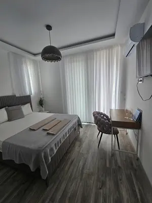 a bedroom with a bed and a table and a desk at La Vida Apartments in Babalonija