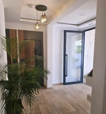 a hallway with a door and a plant at La Vida Apartments in Babalonija