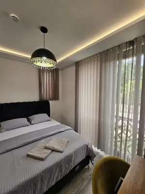 a bedroom with a bed and a large window at La Vida Apartments in Babalonija