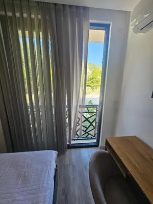 a bedroom with a bed and a large window at La Vida Apartments in Babalonija