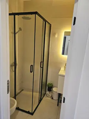 a bathroom with a shower with a glass door at La Vida Apartments in Babalonija