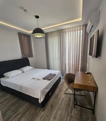 a bedroom with a bed and a table and a chair at La Vida Apartments in Babalonija