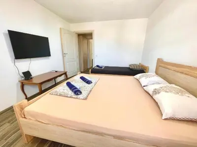 a bedroom with a large bed with a flat screen tv at KAP Apartments in Sutomore