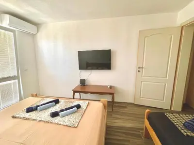 a hotel room with two beds and a television at KAP Apartments in Sutomore