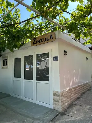 a white building with a sign on top of it at Zinzula 1 in Bar
