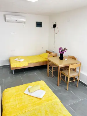 a room with two beds and a table with flowers at Zinzula 1 in Bar