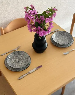 a table with two plates and a vase with purple flowers at Zinzula 1 in Bar