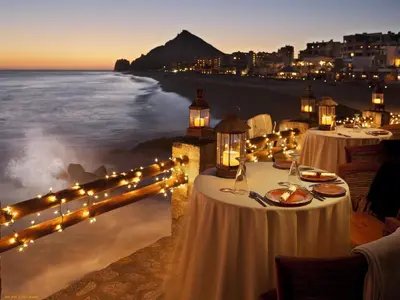 a group of tables with lights on the beach at Montebar1 in Bar