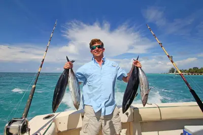a man holding two fish on a boat at Montebar1 in Bar