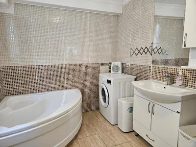 a bathroom with a tub sink and a washing machine at Montebar1 in Bar
