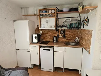 a small kitchen with white appliances and a brick wall at Montebar1 in Bar