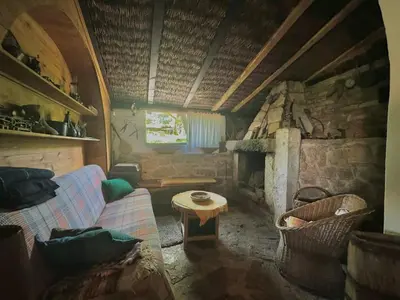a living room with a couch and a stone fireplace at Artistic Garden House in Cetinje