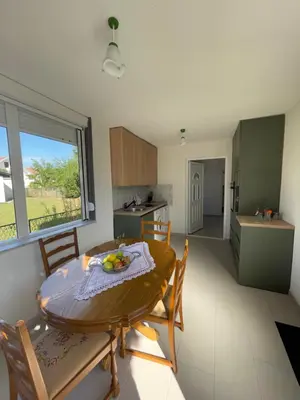 a kitchen and dining room with a table and chairs at Grapefruit Haus in Donji Štoj