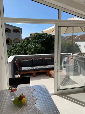 a patio with a couch and a table on a balcony at Grapefruit Haus in Donji Štoj