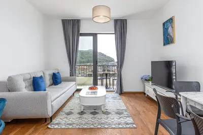 a living room with a couch and a tv at Adriatic Residence in Budva