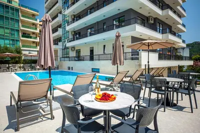 a patio with tables and chairs next to a pool at Adriatic Residence in Budva