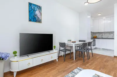 a living room with a tv and a table with chairs at Adriatic Residence in Budva