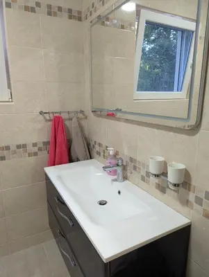 a bathroom with a white sink and a mirror at Villa Seventh Heaven in Sutomore
