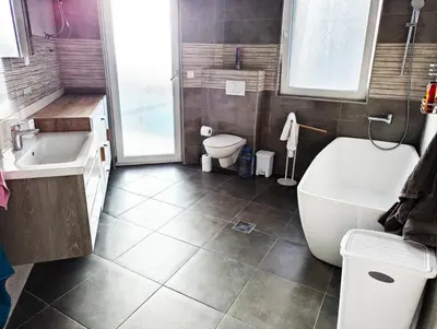 a bathroom with a tub and a toilet and a sink at Villa Seventh Heaven in Sutomore